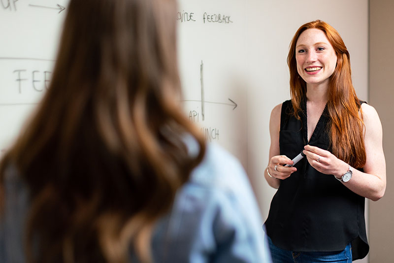 female leader presenting to the entire organization